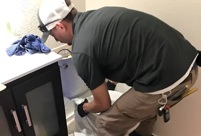 View of water flushing down a white toilet.